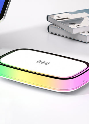 Gradient-colored electronic device on a white surface with books in the background