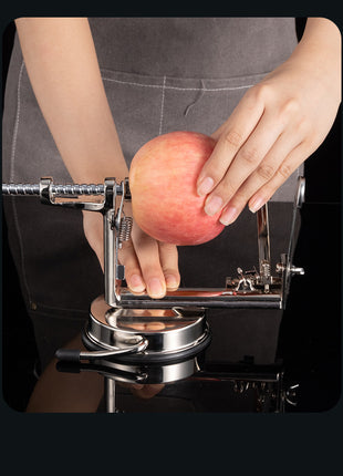Person using an apple peeler with a red apple on a black background