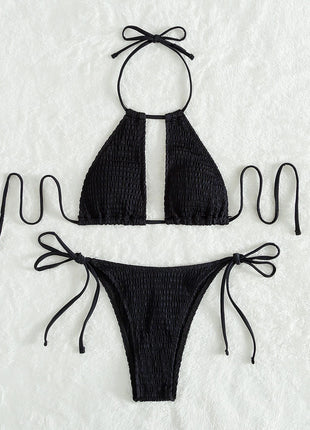 Black bikini set with smocked texture on a textured white background