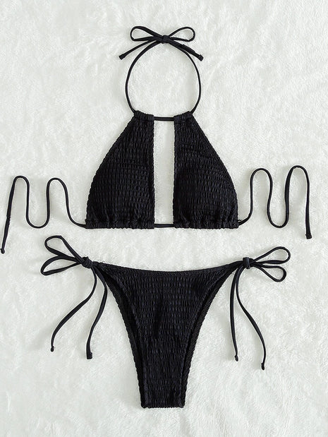 Black bikini set with smocked texture on a textured white background
