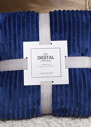 Blue textured blanket with a white label on a gray surface