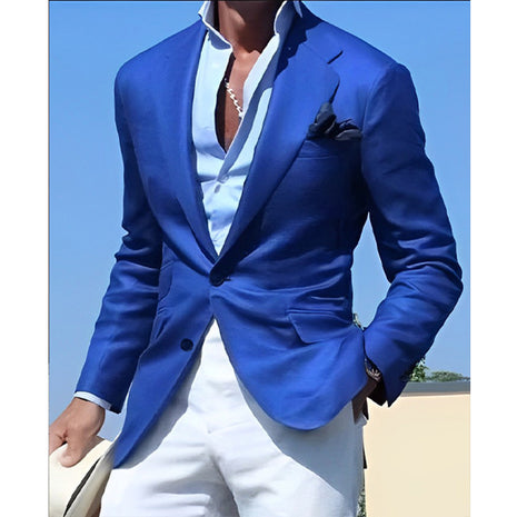 Person wearing a blue blazer over a white shirt with a clear blue sky background
