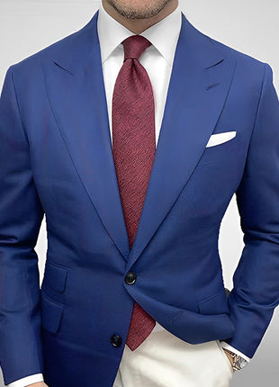 Blue suit jacket with a red tie on a plain background