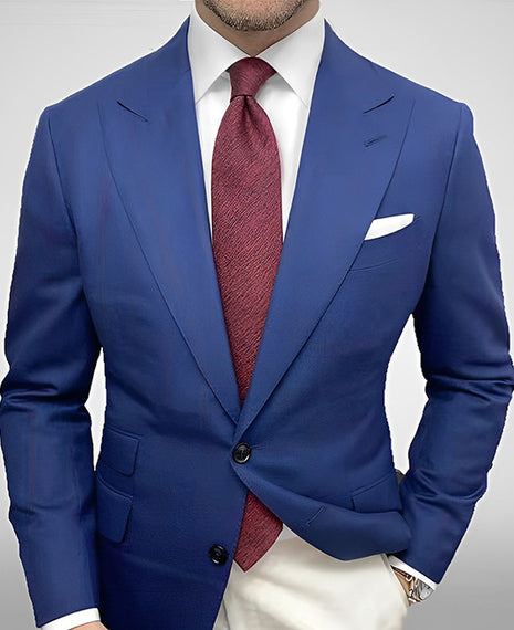 Blue suit jacket with a red tie on a plain background
