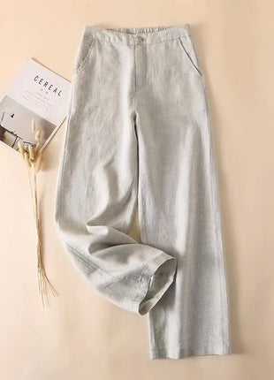 Light gray pants on a beige background with a magazine.