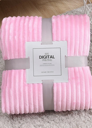 Pink textured blanket with a label on a gray surface