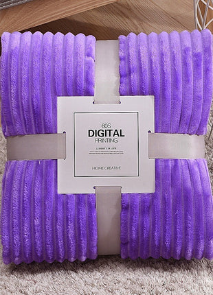 Purple blanket with a brand tag on a carpeted floor