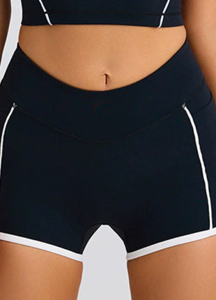 Black athletic shorts with white accents on a neutral background
