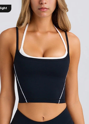 Black sports bra with white trim worn by a model on a light gray background