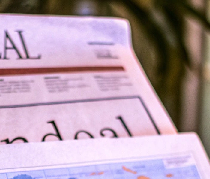 Newspaper with 'Blendeal' branding featuring a world map on a blurred background