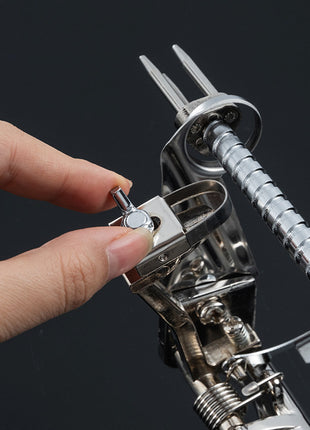 Close-up of a hand using a metal tool on a black background