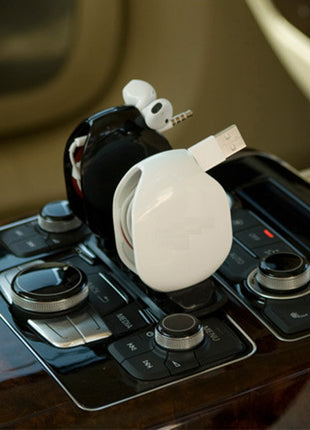 Car gear shift with a white car keychain attached on a blurred interior background