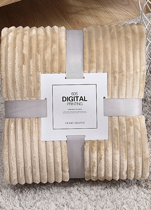 Beige textured blanket with a brand tag on a gray surface