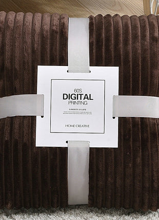 Brown textured blanket with a white label on a light gray surface