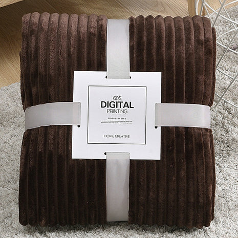 Brown textured blanket with a white label on a light gray surface