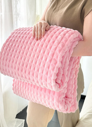 Person holding a pink textured blanket in a bright room