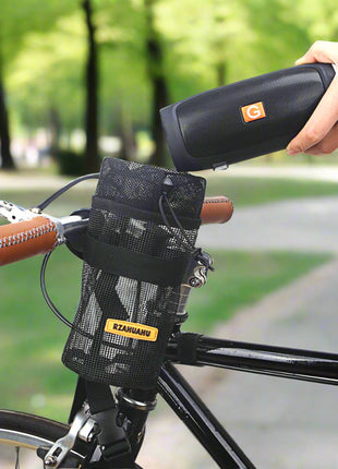 Person using a portable device on a bicycle with a black bag attached to the handlebar.