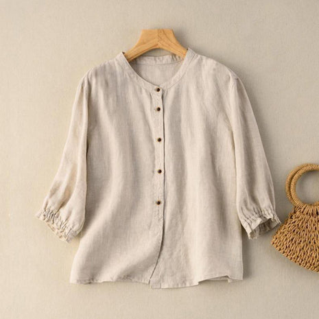 Beige blouse on a wooden hanger with a woven bag on a beige background