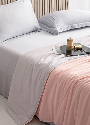 Bed with white bedding and a pink blanket, featuring a small round table with items on it.