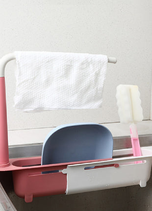 Pink and white dish drying rack with a blue dish inside, hanging over a sink.