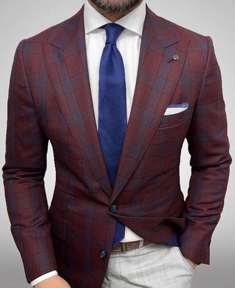 Maroon checkered suit with blue tie and white shirt on a gray background