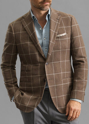 Man wearing a brown checkered blazer over a light blue shirt on a gray background