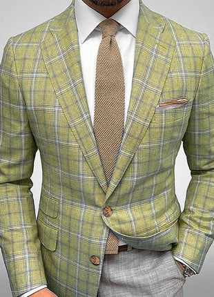 Green plaid suit with a brown tie and pocket square on a gray background
