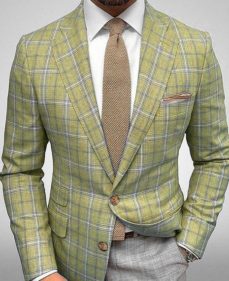Green plaid suit with a brown tie and pocket square on a gray background