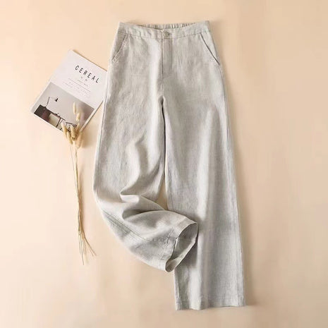 Light gray pants on a beige background with a magazine.