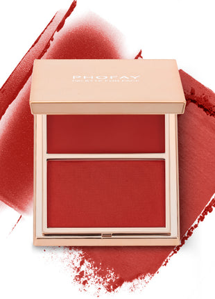 A selection of PHOFAY Duo Cream & Powder Blush products displayed on a pink surface, with the words 'JUST ENOUGH' visible in the image. The products come in golden-colored compact cases with brushes on one side and pink and red blush shades on the other.