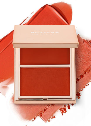 A selection of PHOFAY Duo Cream & Powder Blush products displayed on a pink surface, with the words 'JUST ENOUGH' visible in the image. The products come in golden-colored compact cases with brushes on one side and pink and red blush shades on the other.