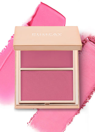 A selection of PHOFAY Duo Cream & Powder Blush products displayed on a pink surface, with the words 'JUST ENOUGH' visible in the image. The products come in golden-colored compact cases with brushes on one side and pink and red blush shades on the other.