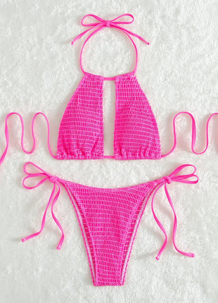 Pink bikini set with mesh design on a textured white background