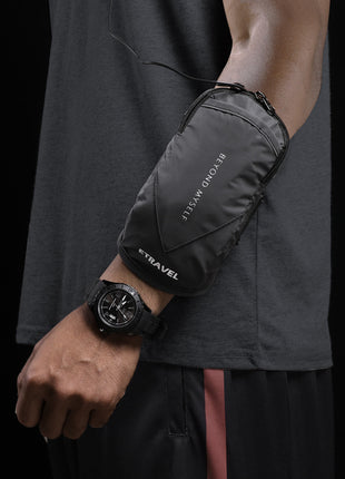 Person wearing a black travel pouch on their arm with a dark background
