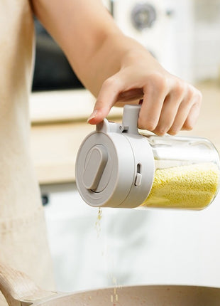 Person using a transparent container with a white lid to pour yellow powder into a bowl.