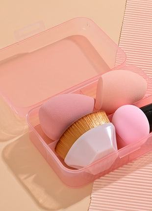Set of makeup brushes in a pink case on a matching pink background