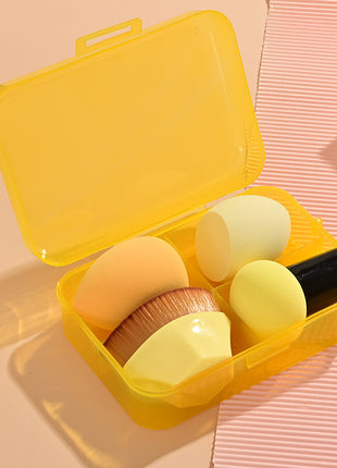 Set of makeup brushes in a yellow case on a pink background