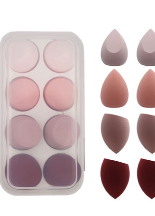 Set of makeup sponges in various shapes and colors on a white background
