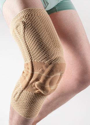 Knee brace on a person's leg against a plain background