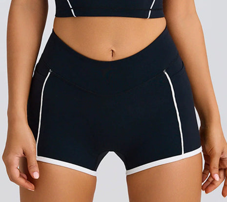 Black athletic shorts with white accents on a neutral background