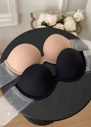 Black and beige bra on a black stand with flowers in the background