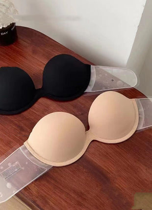 Black and beige bras on a wooden table with a cup of coffee in the background.
