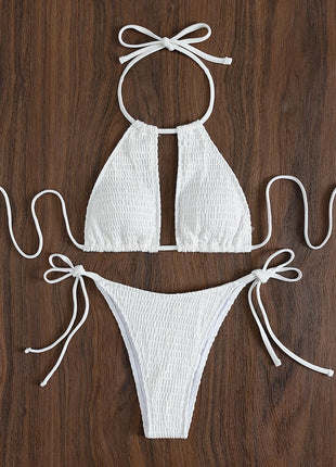 White bikini set with bow details on a wooden surface