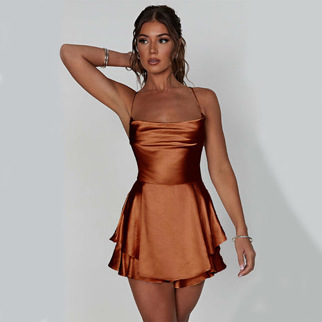 Woman wearing a bronze satin dress against a plain background